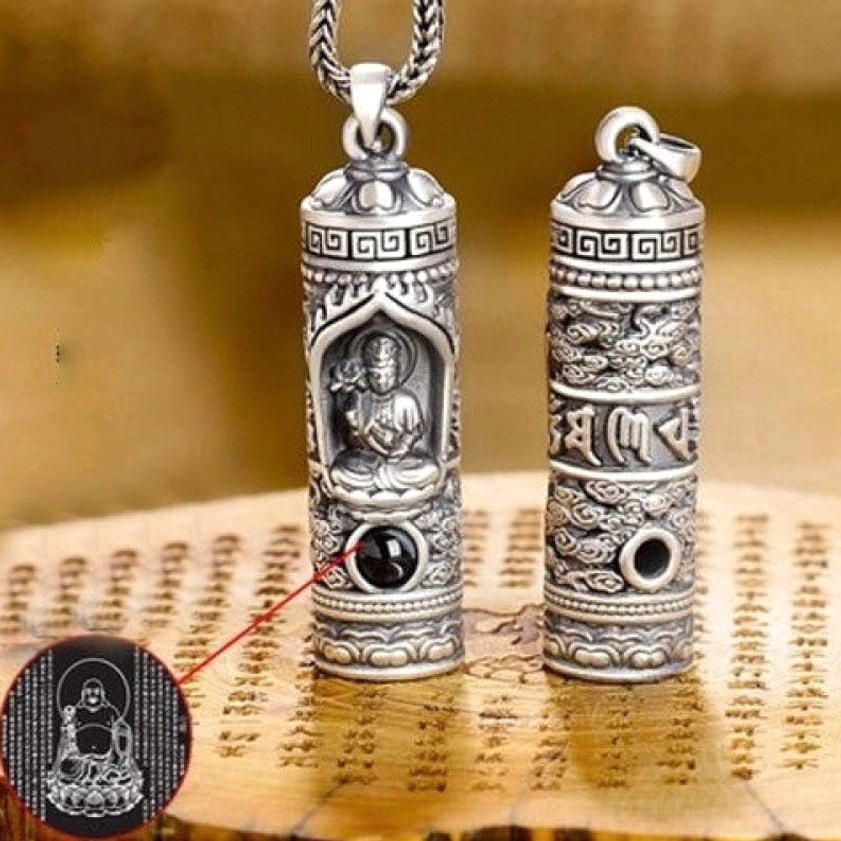 Two cylindrical Buddhist guardian Buddha pendants flat lay showing front embossment and scripture carvings with projection function