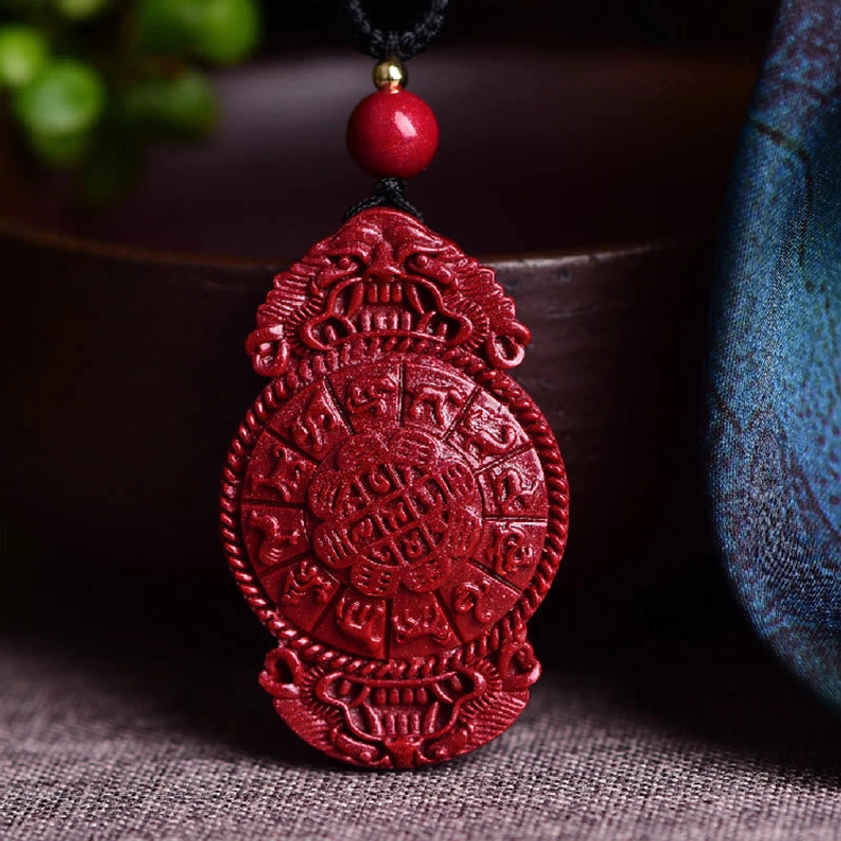Chinese zodiac cinnabar Buddhist pendant on black braided necklace cord displayed on antique book page with size reference