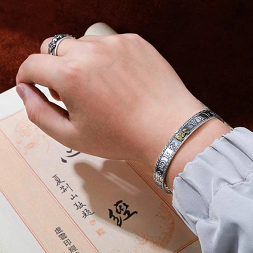 Close-up detail of zodiac natal buddha bracelet showing Sanskrit Heart Sutra engraving and gold guardian deity