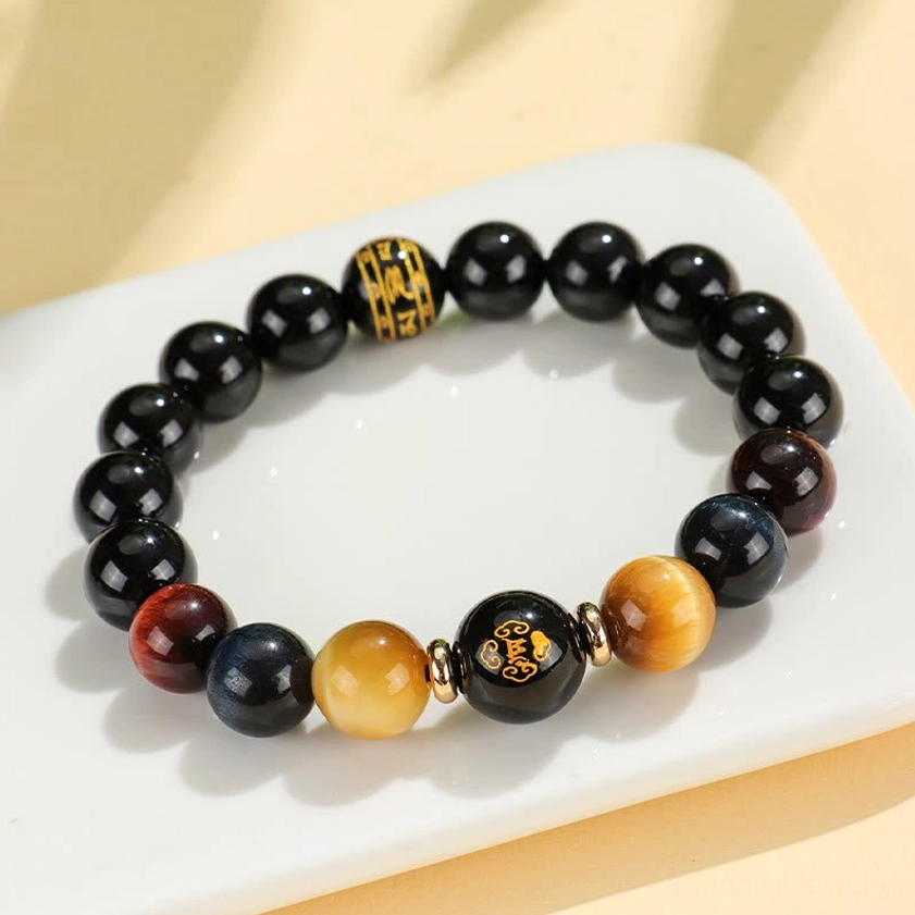 Black onyx tiger eye bracelet detail shot of zodiac natal Buddha charm with alloy gold accent finish